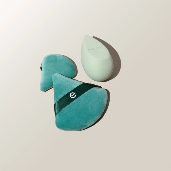 Teal makeup sponges with black bands and one white teardrop sponge, angled