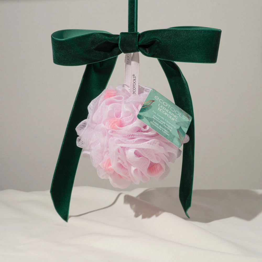 Pink mesh bath pouf with hanging tag and looped ribbon