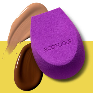 Purple teardrop makeup sponge with dark liquid makeup smear beside it