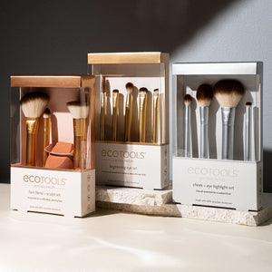 Two boxed eye brush sets on display with gold-toned brushes and rounded bristle tips.