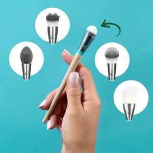 Hand holding an interchangeable makeup brush with beige handle and gray bristles