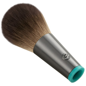 Rounded cheek brush head with dense brown bristles, gray tube and teal end opening