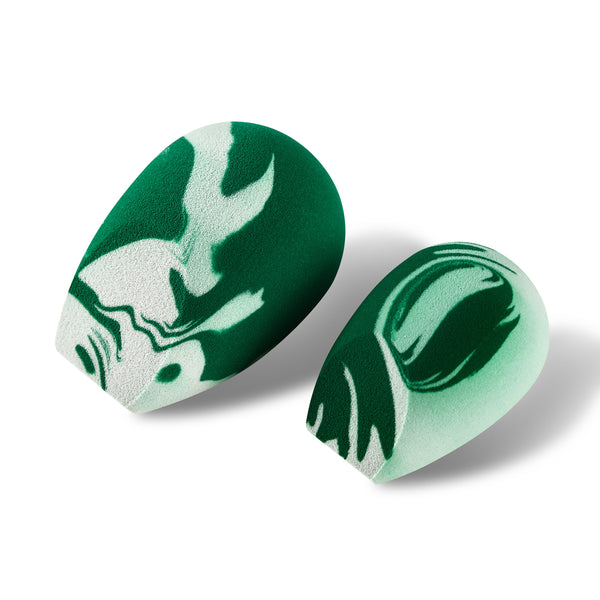 Pair of green-and-white marbled teardrop sponges for facial makeup blending.